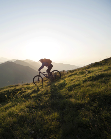 Male mountain biker riding downhill, enjoying on ride and living adventure in the mountain.