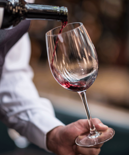 Close up of a person pouring wine in a glass at a winetaste